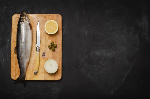 Limon ve soğan bir kesme tahtası üzerinde ringa balığı