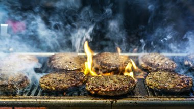 Izgarada hamburgerler, etrafta duman