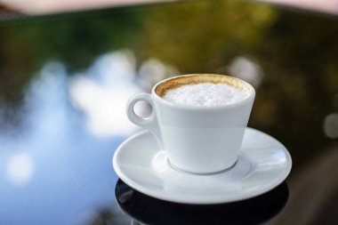 Kahveli Espresso, sınıf masasında, arka planı bokeh olan.