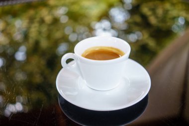 Kahveli Espresso, sınıf masasında, arka planı bokeh olan.