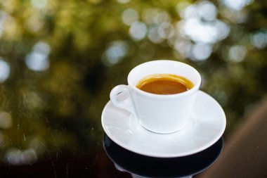 Kahveli Espresso, sınıf masasında, arka planı bokeh olan.