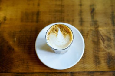 Kahveli Latte İngiltere 'deki tahta masada.