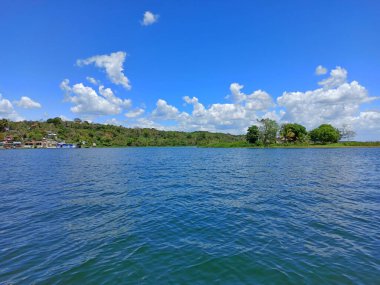 View of San Miguel over the water in sunny day, Flores, Peten, Guatemala. Vacation concept clipart