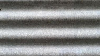 Yinelenen çizgileri, pürüzlü dokuyu ve ince tonsal varyasyonları gösteren çinko levhanın yakın görüntüsü güçlü bir görsel ritme sahip endüstriyel ve soyut bir arkaplan oluşturur..