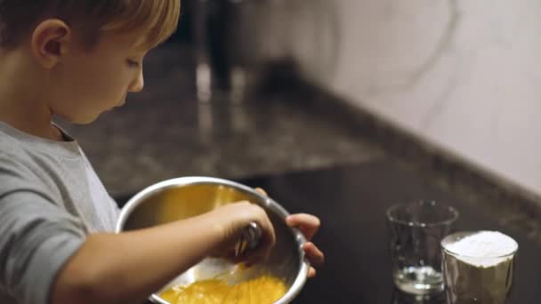 Bambino Monta Tuorli Uovo Con Una Frusta Una Maschera Ferro — Video Stock