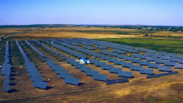 田舎の太陽光発電所 太陽光パネルの空中ビューは 発電のための行に立っている 太陽光発電所の上をドローンが飛ぶ 再生可能エネルギー 代替エネルギー源 ウクライナ — ストック動画