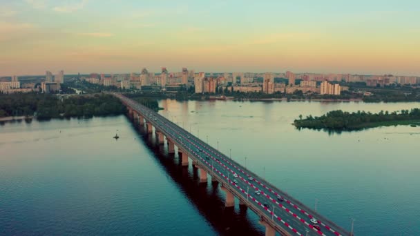 空中俯瞰着桥上的风景 夏天有汽车在移动 而日落在基辅 驾驶员驾驶着汽车从桥上飞驰而过 基辅美丽的风景 — 图库视频影像
