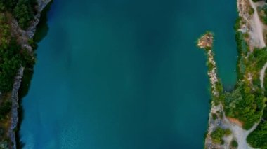  Hava manzarası - büyük nehir ve banliyö çevresiyle yaz manzarasının güzel manzarası. Mavi su yüzeyinde uçan bir dron..