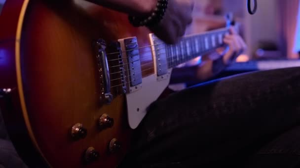 用电吉他弹奏男人的手的特写音乐家会弹奏电吉他 特写镜头 人的手放在吉它颈上弹奏 柔和的焦点 — 图库视频影像
