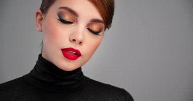 Parlak profesyonel makyajlı güzel bir kadın. Dudaklarında kırmızı ruj olan seksi bir kızın yakın plan sinematik görüntüleri. Moda kahverengi göz makyajlı bir model. Yavaş bir hareket yap. BMPCC4K. 12 bit ProRes.