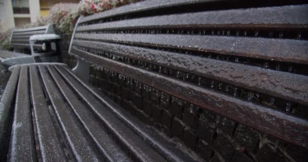 氷柱の凍った街のベンチ 気候変動の氷 冬の氷結したベンチのスローモーション映像 冬の自然災害後の氷の街のベンチ 冬の都市環境 — ストック動画