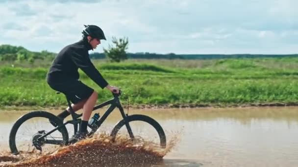 Young Man Drives Large Puddle Black Mountain Bike Cyclist Rides — Stock Video