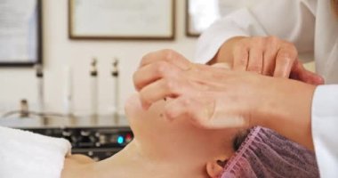 Kozmetik uzmanı göz çevresindeki deriye masaj yapıyor. Yüz bakımı için kozmetik işlemleri yapan bir kaplıcadaki kadın. Güzellik uzmanı bir kadına tedavi edici bir maske takar.. 