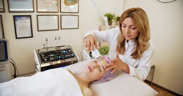 Kobieta Salonie Spa Zabiegach Kosmetycznych Pielęgnacji Twarzy Kosmetolog Robi Kobiecie — Wideo stockowe