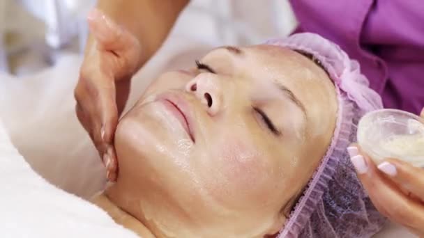 Cosmetoloog Brengt Een Hydraterend Masker Vrouwelijk Gezicht Vrouw Een Spa — Stockvideo