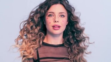 Moda modeli bir fotoğraf stüdyosunda çekilir. Stüdyoda poz veren güzel bir model, parlak ışıklar. Rüzgarda savrulan uzun saçlı güzel bir genç kadın. Saç üfleyen kız. Yavaşlama Hareketi . 