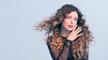 Yüzünde kırmızı kalpler olan güzel bir kız. Rüzgarda savrulan uzun saçlı güzel bir genç kadın. Model stüdyodaki kameraya bakar. Çekici bir sarışının yakın plan yüzü. Yavaş çekim