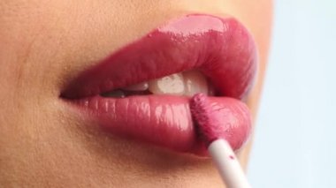 Yakın çekim stilisti, kadın modelin dudaklarına ruj sürüyor. Dudağına ruj süren bir kadın. Profesyonel makyaj. Makyaj ustası özel dersi. Mua yapıyorum. Yavaş çekim.