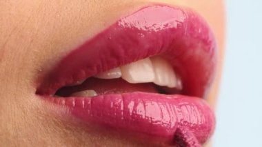 Yakın çekim stilisti, kadın modelin dudaklarına ruj sürüyor. Dudağına ruj süren bir kadın. Profesyonel makyaj. Makyaj ustası özel dersi. Mua yapıyorum. Yavaş çekim.