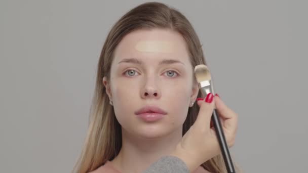 Makeup Καλλιτέχνης Στυλίστας Εφαρμόζει Θεμέλιο Για Πρόσωπο Του Γυναικείου Μοντέλου — Αρχείο Βίντεο
