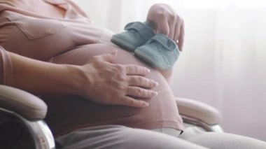 Anasının hamile karnını bir bebekle okşamasını bekliyor. Bebek bekleyen mutlu hamile bir kadın. Hamile bir kadın çocuğuna bakarken kendini mutlu hissediyor. Kadın hamileliği kavramı.