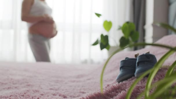 Детская Обувь Фоне Беременной Женщины Ожидающей Ребенка Концепция Материнства Беременность — стоковое видео