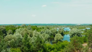 Öğlen vakti, nehrin olduğu güzel bir bahar manzarasının üzerindeki hava manzarası. İnsansız hava aracından gelen hava manzarası güzel bir yaz manzarasının üzerinde uçar.. 