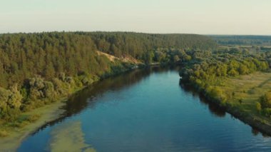Gün batımında nehri olan güzel bir manzaranın üzerindeki hava manzarası. İnsansız hava aracından gelen hava manzarası güzel bir yaz manzarasının üzerinde uçar.. 