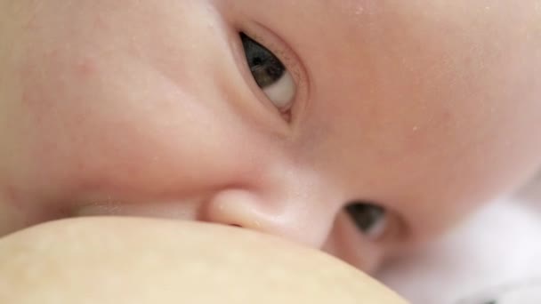 幼児用飲料牛乳のビデオ 母親の手で食事をしながら 小さな白人の赤ん坊のマクロショット 母乳育児 午後の昼寝の前に子供を食べる 呼吸の映画的な映像 — ストック動画