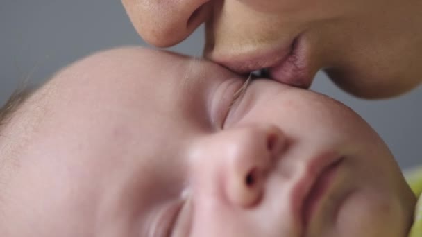 スローモーション息子の足にキスする母親のビデオ 愛する母親のキスのショットを閉じます マクロ映画のフッテージ撮影 ママは足の上で赤ちゃんの指にキス 赤ちゃんのお母さんの世話 — ストック動画