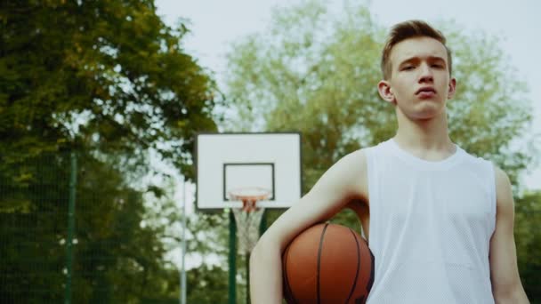 Pojken Står Basketplan Och Håller Basketboll Filmiskt Foto Tonåring Stående — Stockvideo