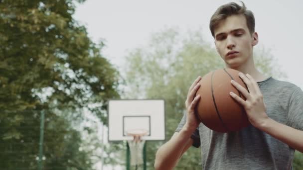 Pojken Står Basketplan Och Håller Basketboll Filmiskt Foto Tonåring Stående — Stockvideo