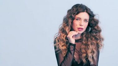 Yüzünde kırmızı kalpler olan güzel bir kız. Rüzgarda savrulan uzun saçlı güzel bir genç kadın. Model stüdyodaki kameraya bakar. Çekici bir sarışının yakın plan yüzü. Yavaş çekim