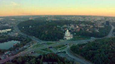 Yazın Kiev 'de günbatımında yol kavşağına giden hava manzarası. İnsansız hava aracı sürüş arabalarıyla otobanın üzerinde uçuyor. Kilise Tapınağı 'nın en iyi manzarası.. 