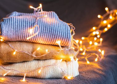 Üç örgü süveter, beyaz ve kahverengi ve bir çelenk.