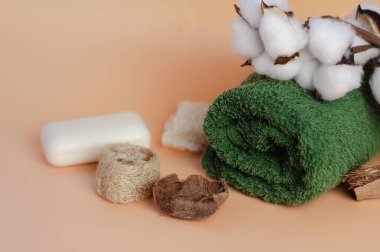 Yeşil, bej arka planda terry havlusu, pamuktan bir dal, yakın plan. Spa tedavileri