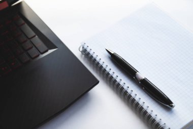 Defter, siyah kalem ve defter masanın üstünde.