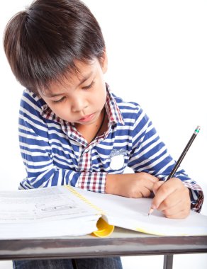 A young boy doing homework on a white background.