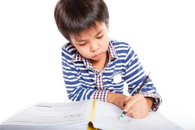 A young boy doing homework on a white background.