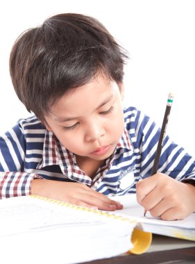 A young boy doing homework on a white background.