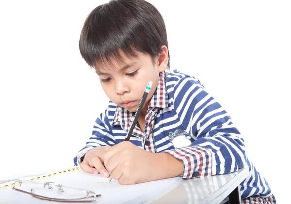 Um menino fazendo lição de casa em um fundo branco . — Fotografia de Stock