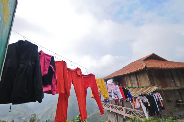 Yüksek dağ köyünde etrafında asılı süslü çoklu renk giysiler — Stok fotoğraf