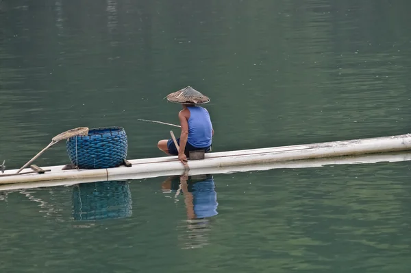 Pescador chinês em jangada de bambu usa método tradicional — Fotografia de Stock