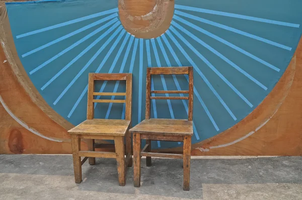Cadeiras básicas de madeira antiga e fundo de parede de ventilador chinês azul — Fotografia de Stock