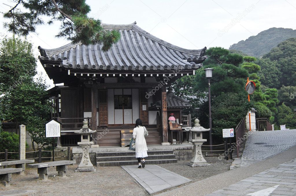 A lady praying at ancient small Japanese shrine
