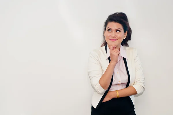 Mujer de negocios está pensando de pie sobre fondo blanco —  Fotos de Stock