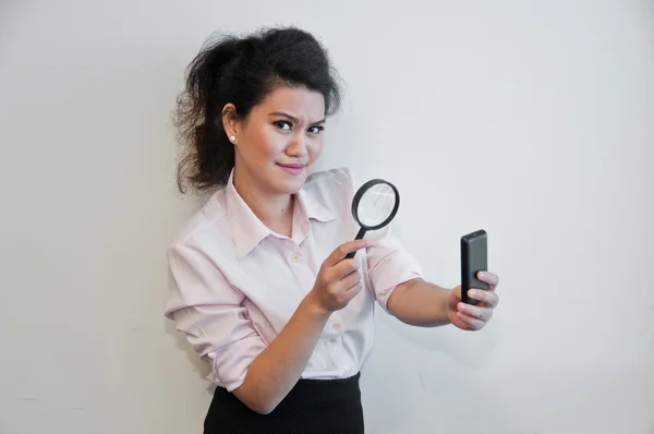 Business woman examine mobile phone by magnifier — Stock Photo, Image