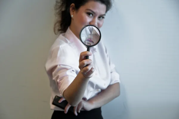 Business woman hold magnifier and a mobile phone — Stock Photo, Image