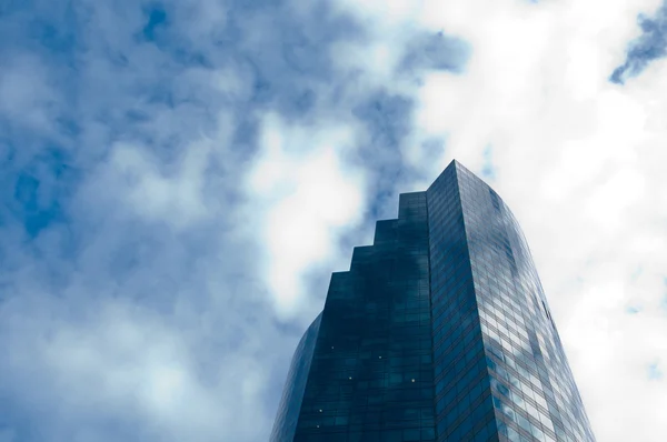 Tall skyscraper office building with cloudy blue sky — Stock Photo, Image