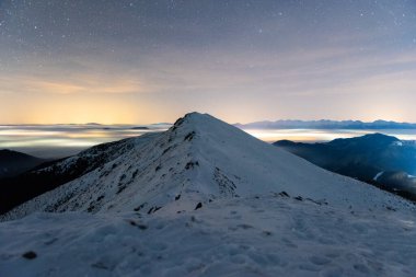 Dağların üzerinde büyülü yıldızlı gece ve kışın sisli vadi, Low Tatras Ulusal Parkı Slovakya